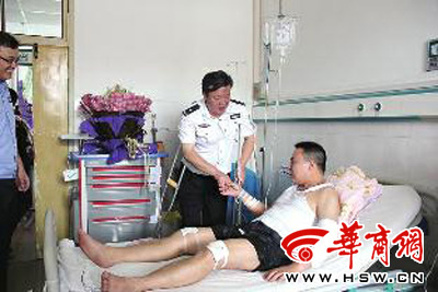 扭伤脚踝的安康市公安局局长杨尚伟拄着双拐，到医院看望王晓勇 本报记者 陈思存 摄